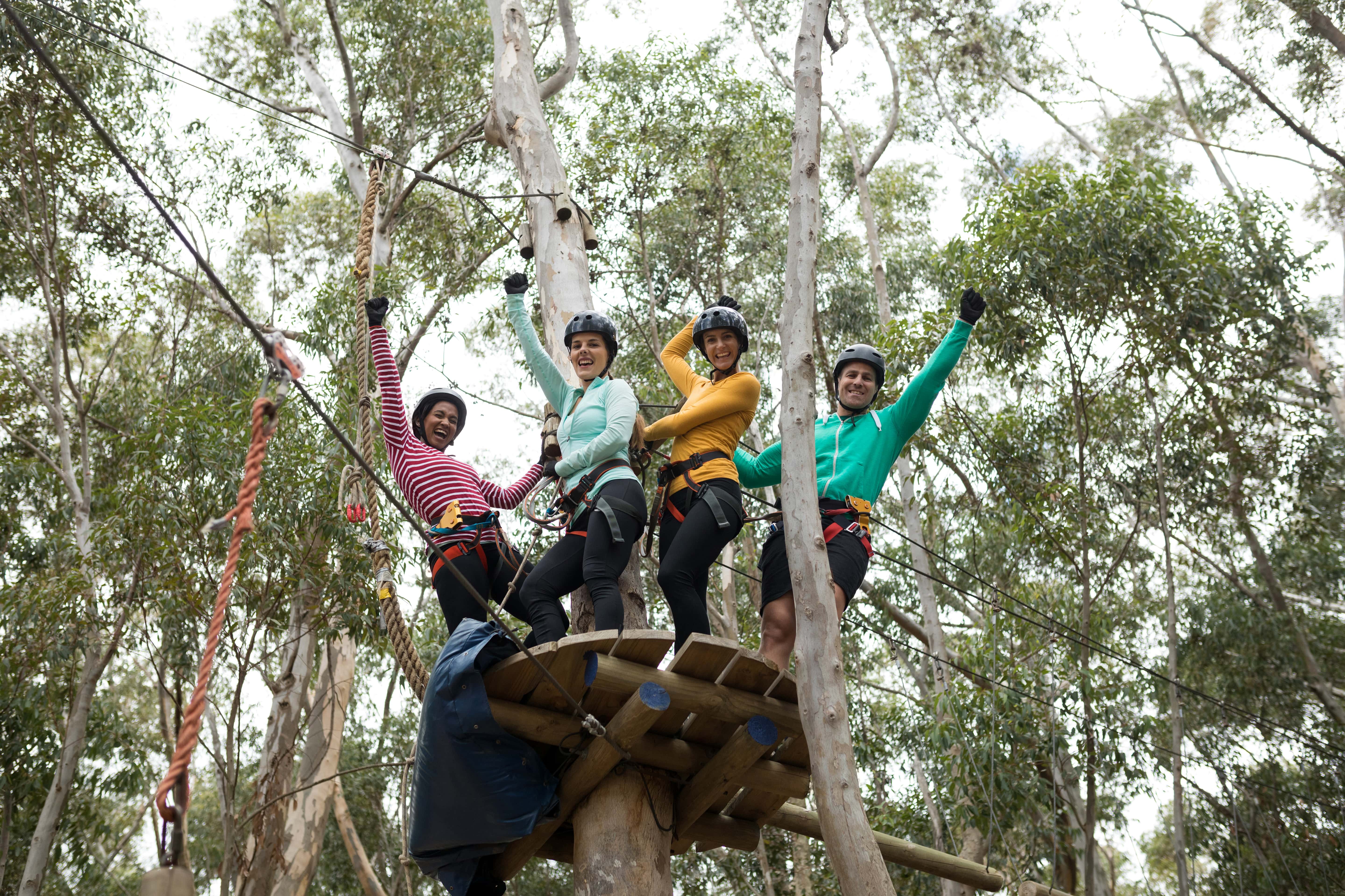 friends-enjoying-zip-line-adventure-in-park